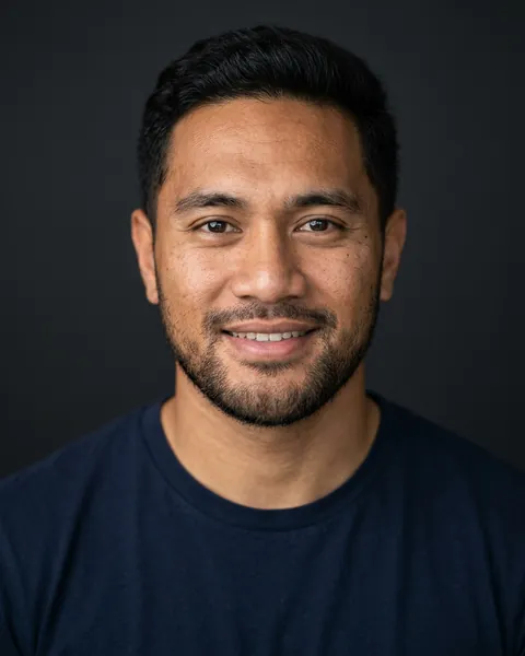 AI-generated portrait of Charlie, a young Pacific Islander man with short dark hair and a dark casual shirt, smiling softly against a dark grey backdrop.